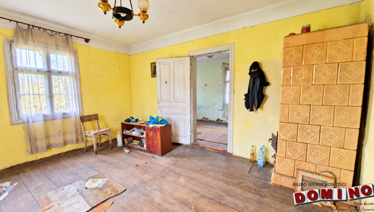 Zaniedbany salon z kaflowym piecem