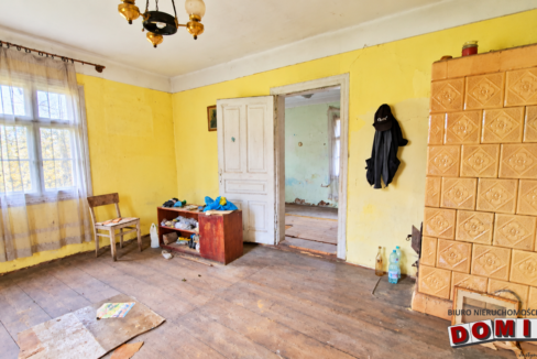 Zaniedbany salon z kaflowym piecem